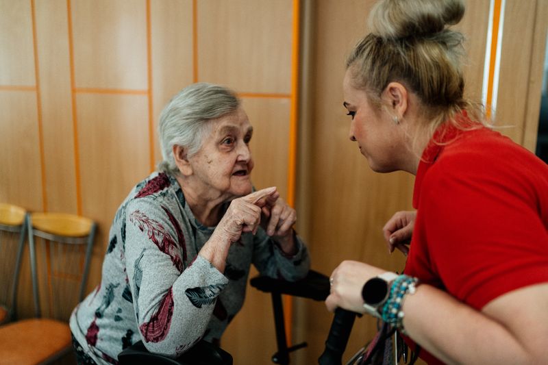 Donna anziana e assistente in conversazione calorosa